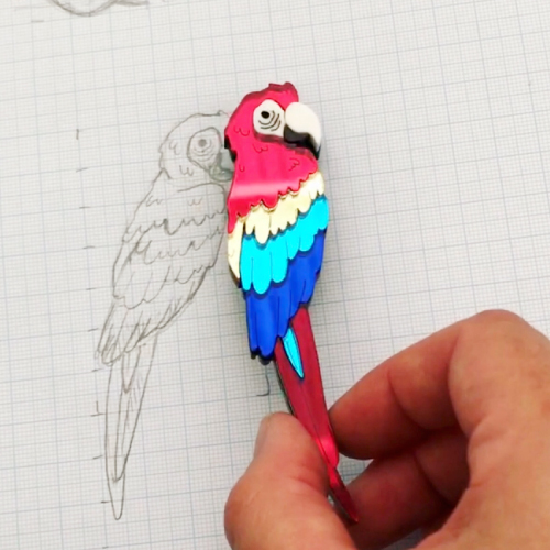 sketch of a bird on graph paper, next to the final laser cut brooch