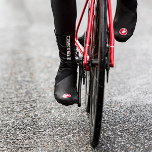 Feet of a cyclist wearing Castelli overshoes who is cycling towards the camera