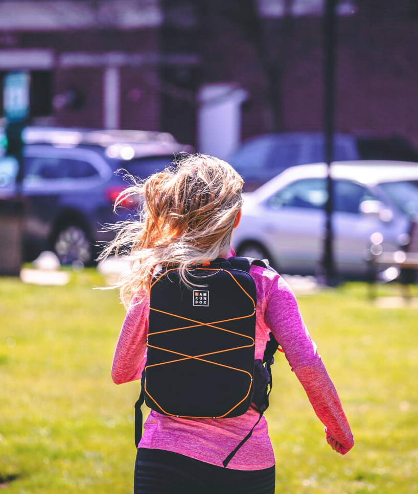 Girl running wearing IAMRUNBOX Backpack Pro